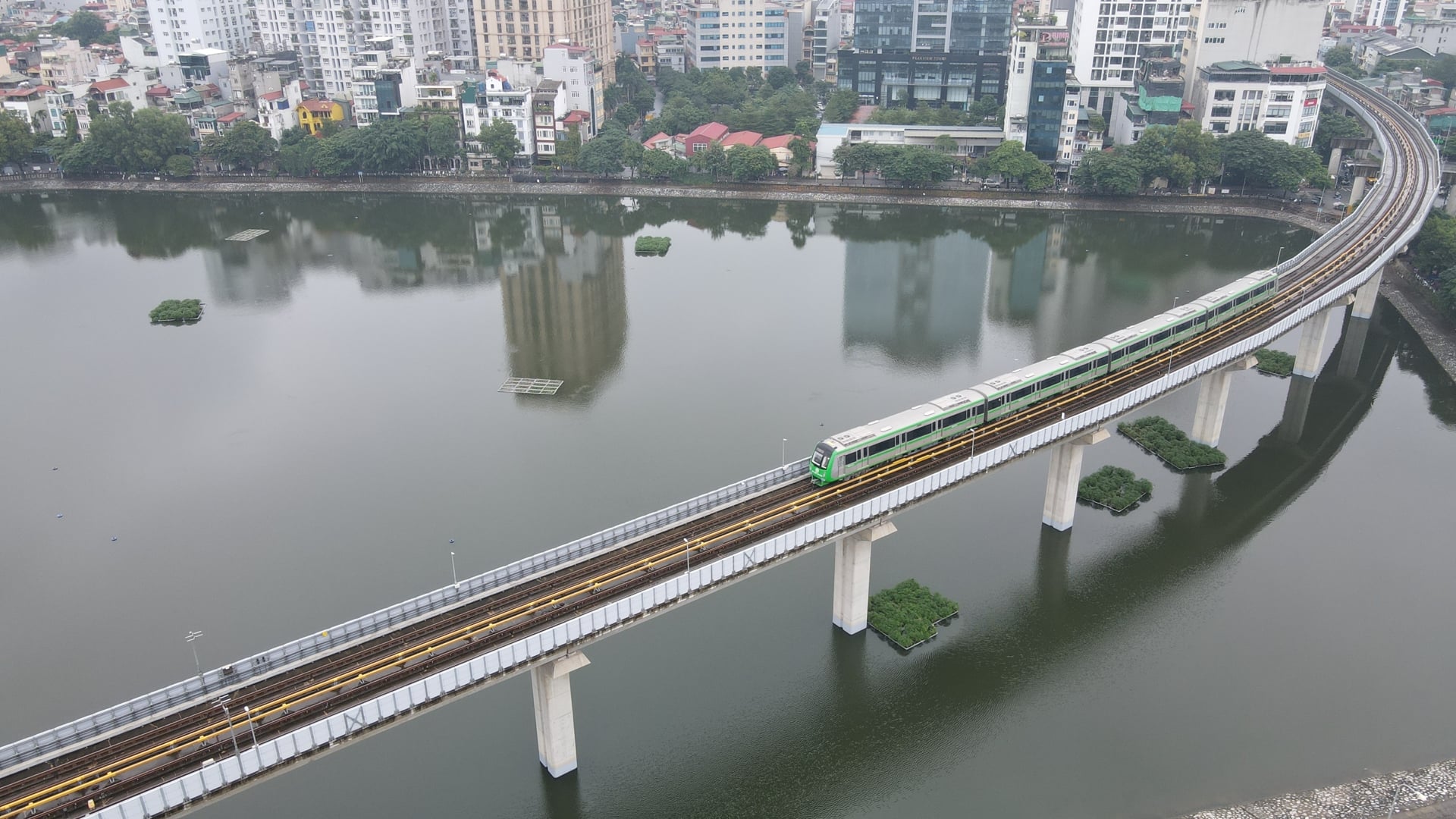 MIK Group ra mắt Forestia, bước ngoặt chiến lược đô thị 2026 2 Tuyến metro trên cao chạy qua khu vực hồ nước tại Hà Nội, minh họa mô hình đô thị TOD
